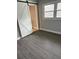 This bedroom features new gray flooring, a sliding barn door, and a bright window for lots of natural light at 2405 Cross Nw St, Atlanta, GA 30318