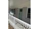 Close-up of a mint front door, with white porch railings, and gray brick exterior at 2405 Cross Nw St, Atlanta, GA 30318