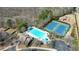 Aerial view of a community pool, tennis courts, and a playground surrounded by trees at 5470 Beaver Ridge Dr, Cumming, GA 30040
