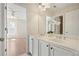 Bathroom with double sinks, white cabinets, and a large mirror, flowing into the adjacent bedroom at 5470 Beaver Ridge Dr, Cumming, GA 30040