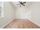 Neutral bedroom with hardwood floors, ceiling fan, and a window for natural light at 5470 Beaver Ridge Dr, Cumming, GA 30040