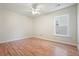 Neutral bedroom with hardwood floors, ceiling fan, and a window for natural light at 5470 Beaver Ridge Dr, Cumming, GA 30040