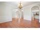 Spacious dining room with hardwood floors, elegant chandelier, and arched entryways at 5470 Beaver Ridge Dr, Cumming, GA 30040