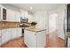 Well-appointed kitchen with white cabinets, granite countertops, island, and hardwood floors at 5470 Beaver Ridge Dr, Cumming, GA 30040