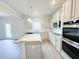 Bright kitchen with stainless appliances, granite counters, island, and white cabinets at 5518 Legacy Trl, Douglasville, GA 30135