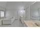 Bright bathroom featuring a large soaking tub, double vanity with mirrors, and tile flooring at 901 Blue Sky Rdg, Snellville, GA 30078