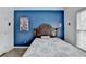 Bedroom featuring a dark blue accent wall, a queen bed, and a large window for natural light at 901 Blue Sky Rdg, Snellville, GA 30078