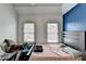 Bedroom featuring a large window and wood floors, plus a bold blue accent wall at 901 Blue Sky Rdg, Snellville, GA 30078
