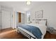 Bedroom with hardwood floors, closet space, a bed with a blue throw, and closet organizer at 127 Oldenburg Dr, Riverdale, GA 30274
