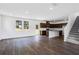 Open-concept living room with hardwood flooring flowing into a kitchen featuring dark cabinets and stainless steel appliances at 209 Groveton Ct, Euharlee, GA 30145