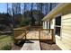 Exterior shot of the backyard, featuring a deck, yellow siding, and mature trees at 2892 Cardinal Lake Dr, Duluth, GA 30096