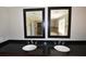 Bathroom with double vanity, black countertops, and dual mirrors at 2892 Cardinal Lake Dr, Duluth, GA 30096