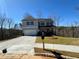 Two-story home with a gray exterior, dark shutters, a covered front porch, and a driveway leading to the garage at 5342 Legacy Trl, Douglasville, GA 30135