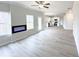 Bright living room with modern fireplace, ceiling fan, and open view to the kitchen at 5342 Legacy Trl, Douglasville, GA 30135