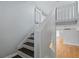 Well-lit staircase featuring hardwood steps and white railing at 700 Bayliss Dr, Marietta, GA 30068