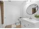 Bathroom featuring updated vanity, round mirror, and shower with tiled walls at 73 Rumson Se Ct, Smyrna, GA 30080