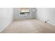 Empty bedroom featuring carpeted floors, a window, and a modern lamp at 73 Rumson Se Ct, Smyrna, GA 30080