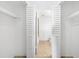 Spacious walk-in closet with white shelving and slat doors, leading to the bathroom with tile floors at 73 Rumson Se Ct, Smyrna, GA 30080