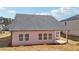 Back view of home with multiple windows, gray roof, and an unfinished yard at 6902 Winchester Pl, Fairburn, GA 30213