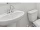 Modern bathroom with a white pedestal sink and toilet, showcasing a clean and minimalist design at 6902 Winchester Pl, Fairburn, GA 30213