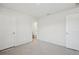 Empty bedroom featuring two doors and carpet with plastic covering at 6902 Winchester Pl, Fairburn, GA 30213