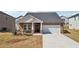 Charming single Gathering home with brick and white accents and an attached two car garage at 6902 Winchester Pl, Fairburn, GA 30213
