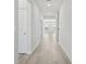 Bright hallway with light wood flooring, white walls and natural light at 6902 Winchester Pl, Fairburn, GA 30213