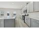 Contemporary kitchen featuring sleek countertops, stainless appliances, a center island and a large window at 6902 Winchester Pl, Fairburn, GA 30213
