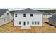 Back exterior featuring white siding, multiple windows, and a small patio at 7758 Sheffield Ter, Fairburn, GA 30213