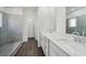 Bathroom featuring double vanity, large mirror, glass shower doors, and wood flooring at 7758 Sheffield Ter, Fairburn, GA 30213