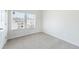 Bright bedroom featuring neutral walls, plush carpet, and a large window at 7758 Sheffield Ter, Fairburn, GA 30213
