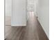 Neutral hallway with grey hardwood flooring and white wall paint throughout the home at 7758 Sheffield Ter, Fairburn, GA 30213