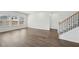 Spacious living room featuring hardwood floors, multiple windows, and staircase at 7758 Sheffield Ter, Fairburn, GA 30213