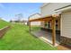 A spacious backyard with a covered patio, stone accents, and lush green grass at 1340 Slaton Manor Dr, Conyers, GA 30012