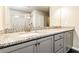 Bathroom with a dual sink vanity, granite counters, and a tiled shower at 1340 Slaton Manor Dr, Conyers, GA 30012