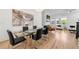 Dining area boasts a glass table with black chairs, modern art, and hardwood floors open to the living area at 343 Concord St, Alpharetta, GA 30009