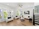 Bright living room with large windows, hardwood floors, white couches, and access to the staircase at 343 Concord St, Alpharetta, GA 30009