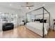 Bright main bedroom features a canopy bed, hardwood floors, and large windows with neighborhood views at 343 Concord St, Alpharetta, GA 30009