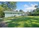 Expansive green backyard featuring the home's painted brick exterior and deck at 1467 Thompson Pl, Decatur, GA 30032