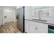 Kitchen featuring stainless steel refrigerator, sink, and white cabinets at 1467 Thompson Pl, Decatur, GA 30032
