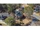 An aerial view of a brick home with a dark roof, back deck, and a driveway surrounded by trees in a suburban neighborhood at 5679 Brookstone Nw Walk, Acworth, GA 30101