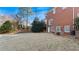 The backyard of this brick home features a sprawling lawn, mature trees, and a covered patio area at 5679 Brookstone Nw Walk, Acworth, GA 30101