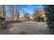 The spacious backyard features a well maintained lawn bordered by mature trees and a brick retaining wall at 5679 Brookstone Nw Walk, Acworth, GA 30101