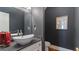 Stylish powder room with dark gray walls, an oval vessel sink, and modern fixtures at 5679 Brookstone Nw Walk, Acworth, GA 30101