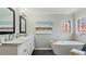 Elegant bathroom featuring a soaking tub, double vanity with marble countertop, and decorative stained-glass window at 5679 Brookstone Nw Walk, Acworth, GA 30101