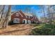 Two-story red brick home with black shutters surrounded by lush greenery and mature trees at 5679 Brookstone Nw Walk, Acworth, GA 30101