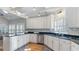 Bright kitchen featuring white cabinets, black countertops, stainless steel appliances, and hardwood floors at 5679 Brookstone Nw Walk, Acworth, GA 30101