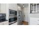 Kitchen featuring stainless steel oven, microwave, and refrigerator next to a doorway and hardwood floors at 5679 Brookstone Nw Walk, Acworth, GA 30101