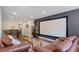 Living room featuring leather sofas, a large projection screen, and hardwood flooring at 5679 Brookstone Nw Walk, Acworth, GA 30101