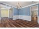 Open-concept dining room with blue walls and hardwood floors, adjacent to other living spaces at 133 Abbey Pointe Way, Suwanee, GA 30024